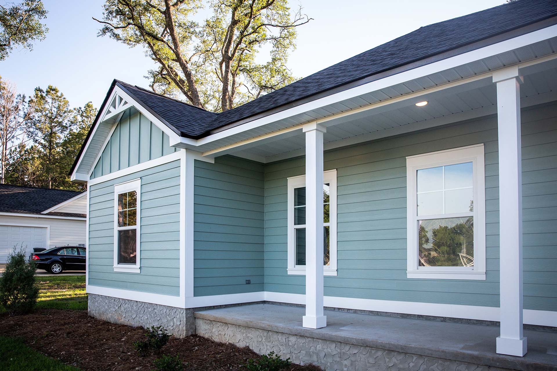 Front view of a brand new construction house with blue siding.