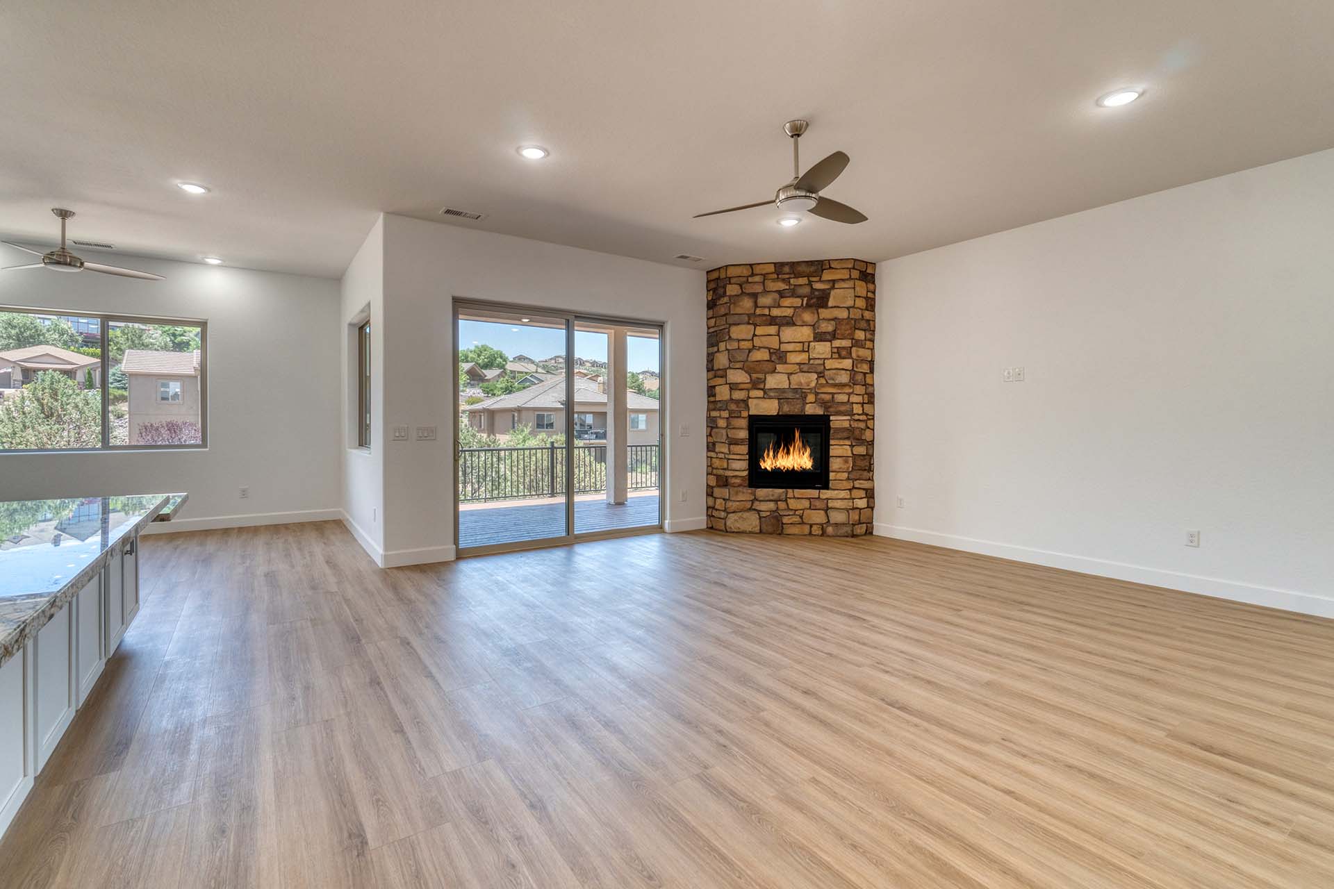 Empty room with a fireplace and laminate wood flooring.