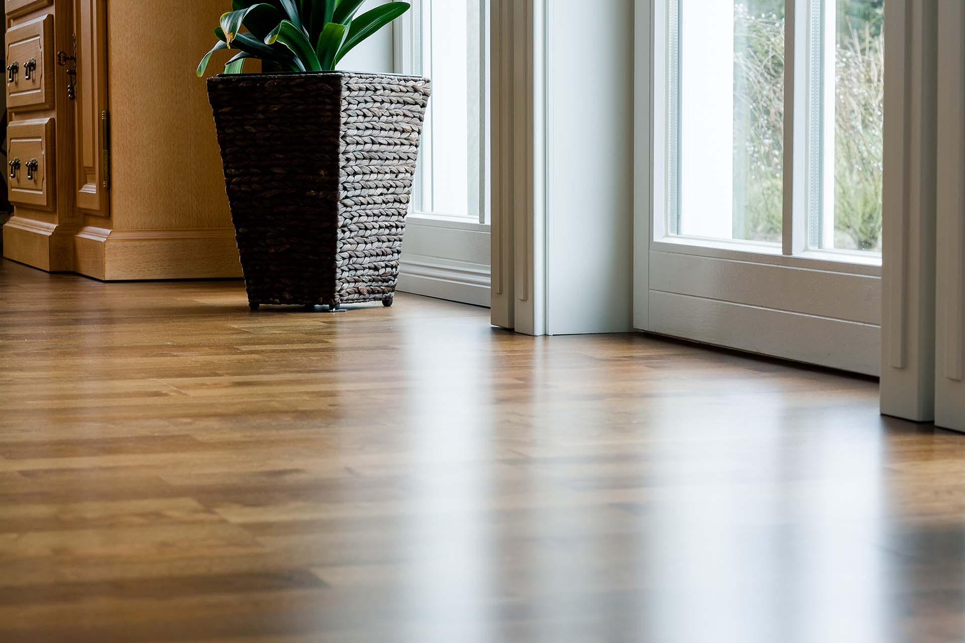 laminate wood flooring near window glass.