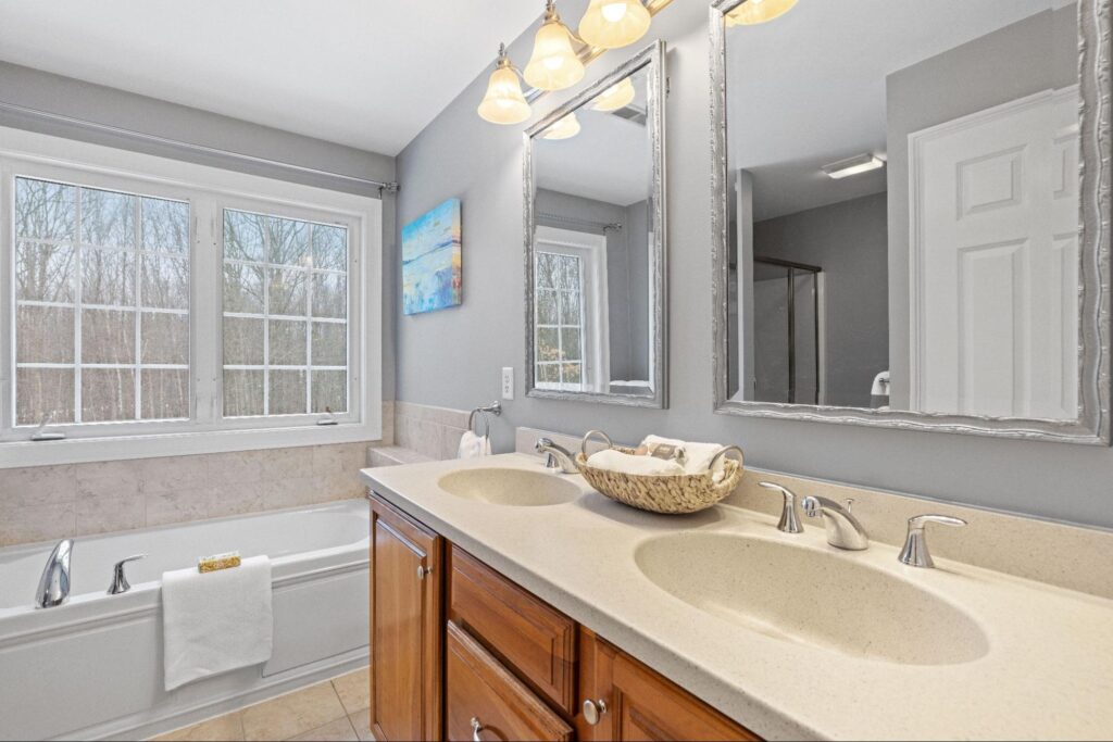 A modern designer bathroom with two sinks and a tub.