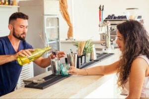 Man making a woman a drink at a bar.