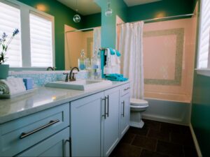 A newly remodeled bathroom featuring a soft palette of pink, light blue, and Tiffany blue hues, creating a fresh and inviting space.